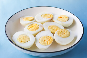 several halved boiled eggs in a plate on a blue background