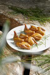 Roasted pigeon in white tableware, spices decorate the table © wei