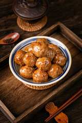 Beef meatballs on wooden table, interior scene with dark background