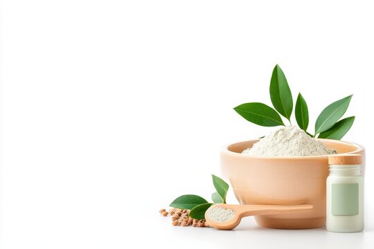 Bowl of bentonite clay and skincare jar with green leaves on a white background