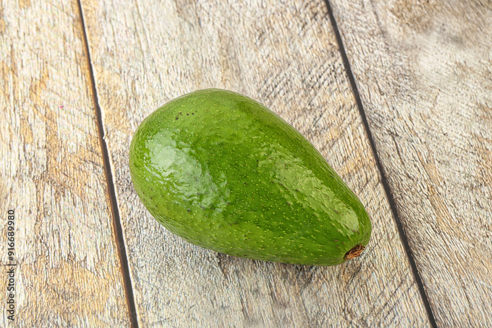 Wall mural ripe green avocado over background