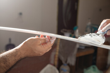 Worker applying putty on material. Renovating home