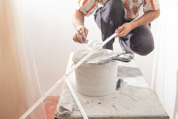 Worker applying putty on material. Renovating home