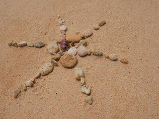 Set of colorful pebbles forming a shape on beach sand background