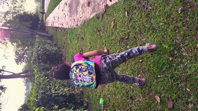 Bangi, Malaysia, May 24, 2023 little girl running and plogging at the park. Plogging is the act of picking up trash while walking.4K Vertical