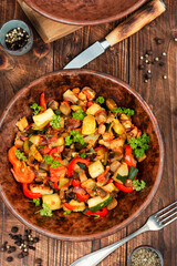 Delicious baked ratatouille on rustic wooden table