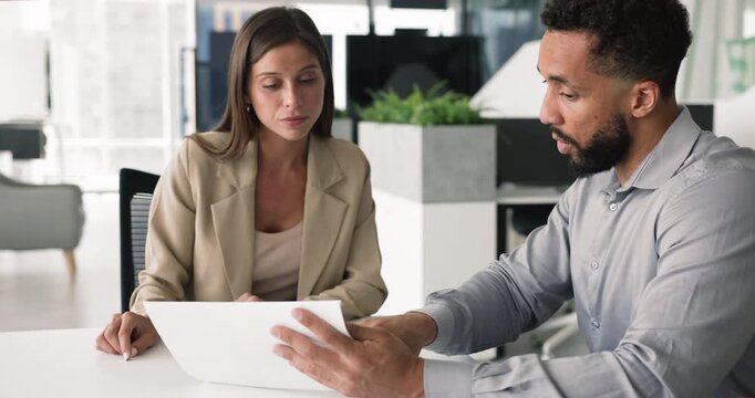 Professional manager met with client in office, holds papers, explaining contract details, pointing to specific sections on legal document, shaking hands, concluding agreement, express mutual respect