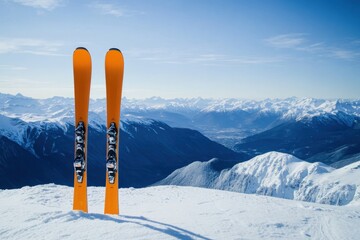 Two orange skis standing vertically on a snowy mountain top with clear blue sky and snowy mountains in the background. Space for text