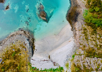 Northern Norway beach with vibrant turquoise waters and rugged coastline
