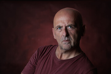 Serious mature man with arms crossed posing in studio portrait