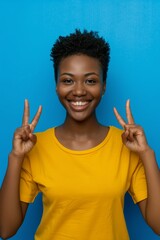 Portrait of cheerful black woman gesturing at discount news, retail promotion, or announcement. Logo, branding notice, and African smile for sales price on blue backdrop.