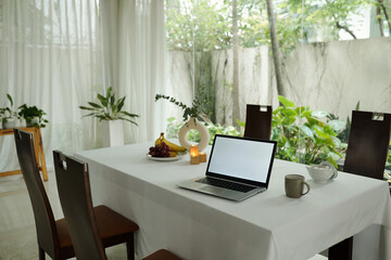 Laptop for online work on dining table in the room