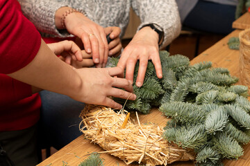 Crafting handmade Christmas wreaths with evergreen branches.