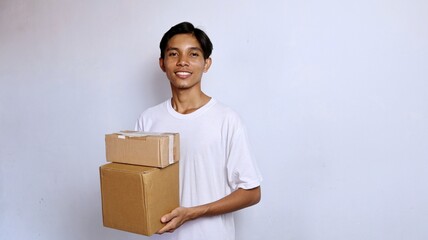 Asian young man smiling wearing white shirt gesturing holding package box