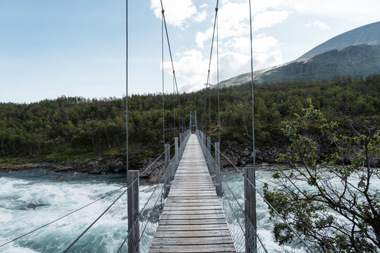 Suspension bridge over river Vuojat&auml;dno on hiking adventure trail called Padjelantaleden through National Parks of Swedish Lapland