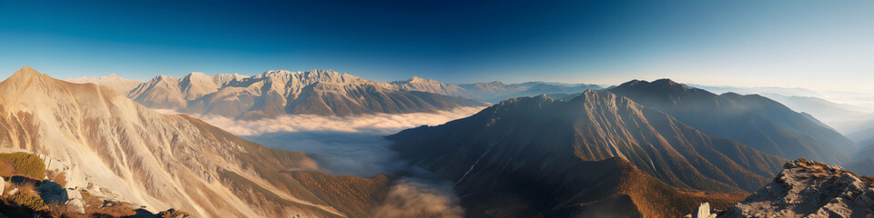 Fototapeta premium A panoramic view of a mountain range with a foggy mist covering the peaks