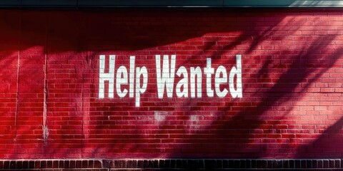 Help Wanted Sign on Red Brick Wall - Job Vacancy Advertisement and Recruitment Opportunity