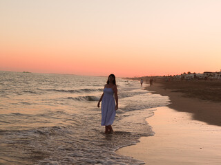 person walking on the beach at sunset