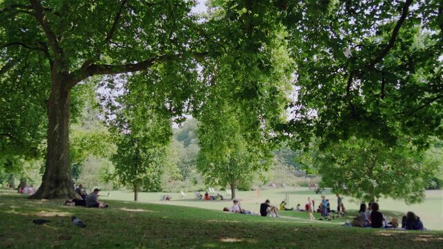 People enjoying a London park.
Wide angle shot of people sitting on the grass in a London Park. People blurred a little for anonymity.