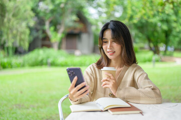 Fototapeta premium Woman Relaxing with Coffee and Smartphone in a Park outdoor table in a serene park, enjoying a moment of relaxation.