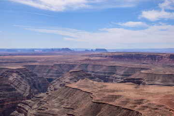 Stunning aerial view from Muley Point, Utah, showcasing the rugged landscape of the desert and the Valley of the Gods. The image captures the vast desert scenery under a clear blue sky - USA