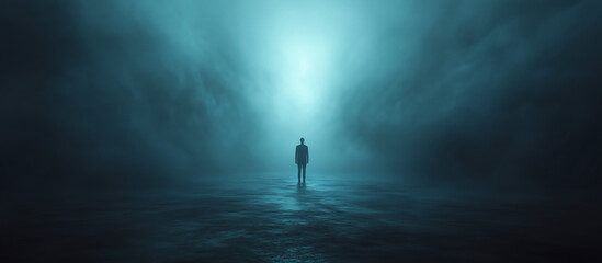 A solitary figure stands shrouded in blue light, adrift in a fog-filled, empty room, casting an ominous silhouette against the encroaching darkness.