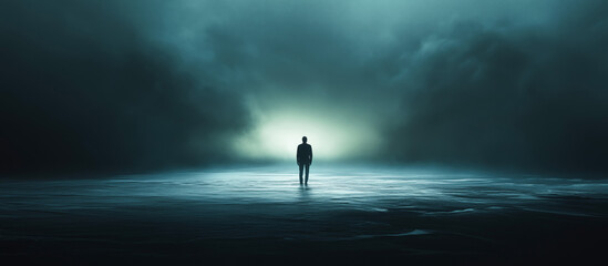 Fototapeta premium Ethereal light bathes a solitary figure, silhouetted against the vast, inky ocean.