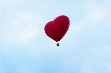 Heart shaped balloon against blue sky.