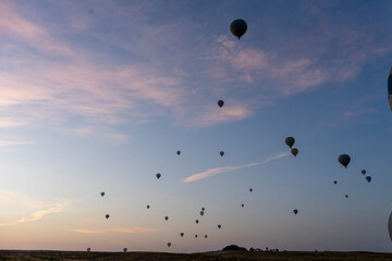 Hot air balloons floating above the hot rising sun
