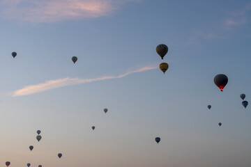 Hot air balloons floating above the hot rising sun