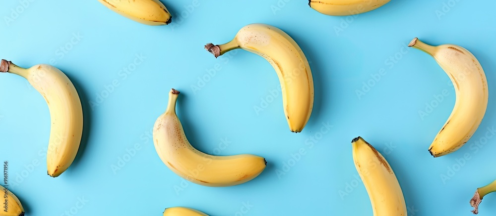Leinwandbilder Top view of a healthy and simple raw food concept with a banana pattern on a blue background in a flat lay style shot with copy space image