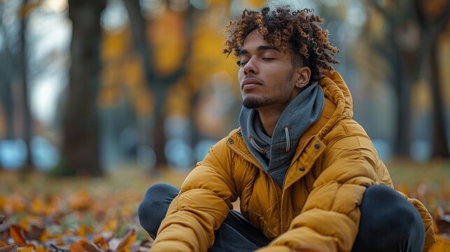 Young man meditating outdoors in autumn park with yellow leaves - Powered by Adobe
