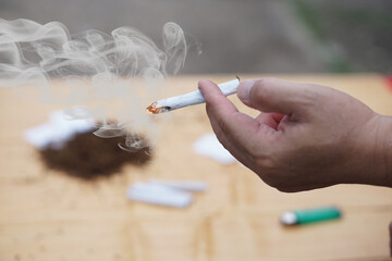 Close up hand holds homemade cigarette for smoking. Concept, smoking is bad for health. Private...