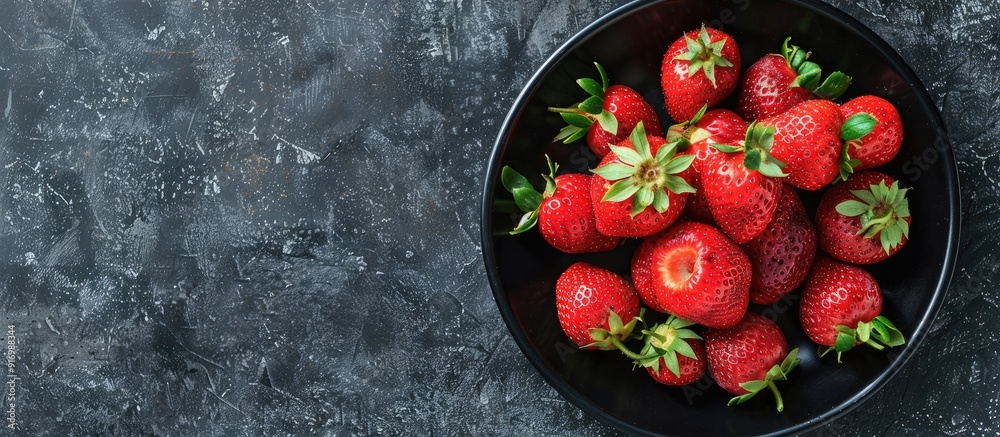 Aufkleber fresh ripe red strawberries displayed on a black round plate against a black background featuring or