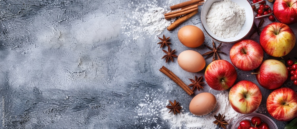 Sticker top view of fresh apples cinnamon flour sugar and eggs on a stone background a copy space image depi