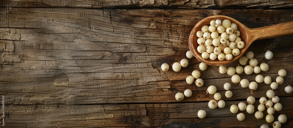 Poster organic white pepper corn in a wooden spoon displayed on a rustic wooden surface with a copy space i