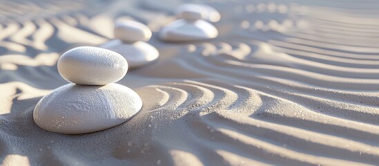 Zen like white stones are arranged neatly on sandy surface with available copy space image