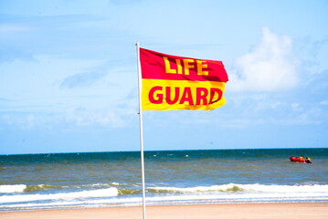Safety at the Shore: Lifeguard Flag on the Sandy Beach