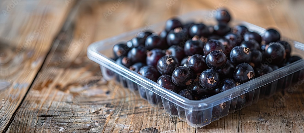 Poster Chokeberry displayed in a plastic box on a wooden table with ample copy space image