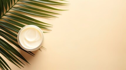 Jar of body cream and palm leaf on color background, top view