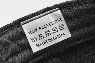 clothing label, mentioning it's made from 100% polyester, five clothing care symbol and...