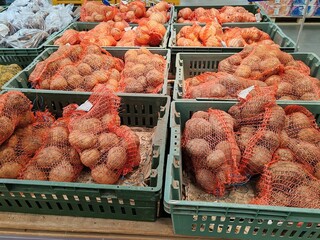 A pile of potatoes are in a green basket