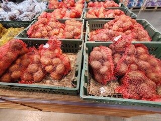 A bunch of red potatoes are in a green container