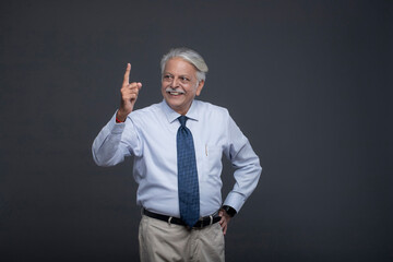 Smiling Senior Pointing Up One Finger