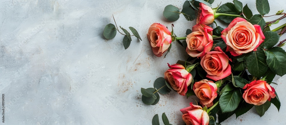 Poster flat lay scene captured from above featuring a rose bouquet with leaves on a light table providing a