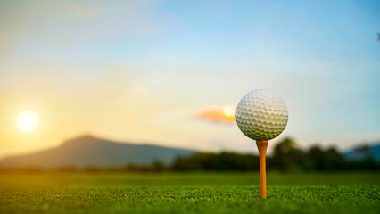 Golf ball on green grass in the evening golf course with sunshine background.
