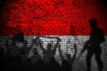 indonesia flag painting on brick wall and Protesters shadow