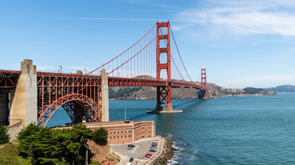 Golden Gate Bridge stretches across San Francisco Bay on a sunny summer day, showcasing its vibrant...