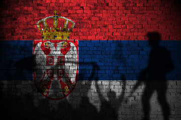 serbia flag painting on brick wall and Protesters shadow