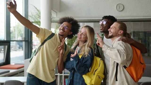 Multiracial students happy smiling diversity friends African men guys males Caucasian girl woman female high school university grimacing together selfie photo record video take picture mobile phone